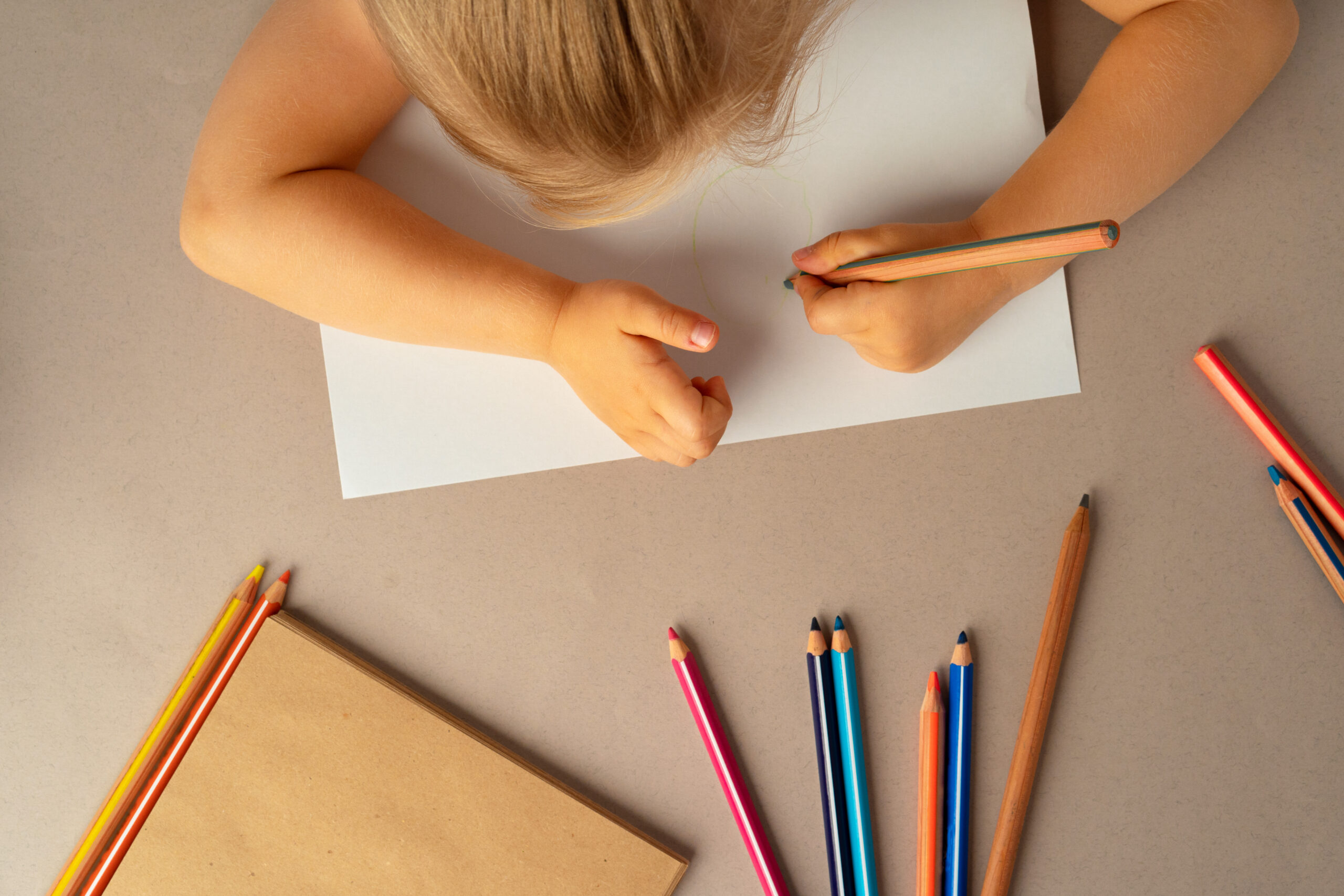Kid's hands writing in open notebook, top view, copy space. To do list, letter to Santa