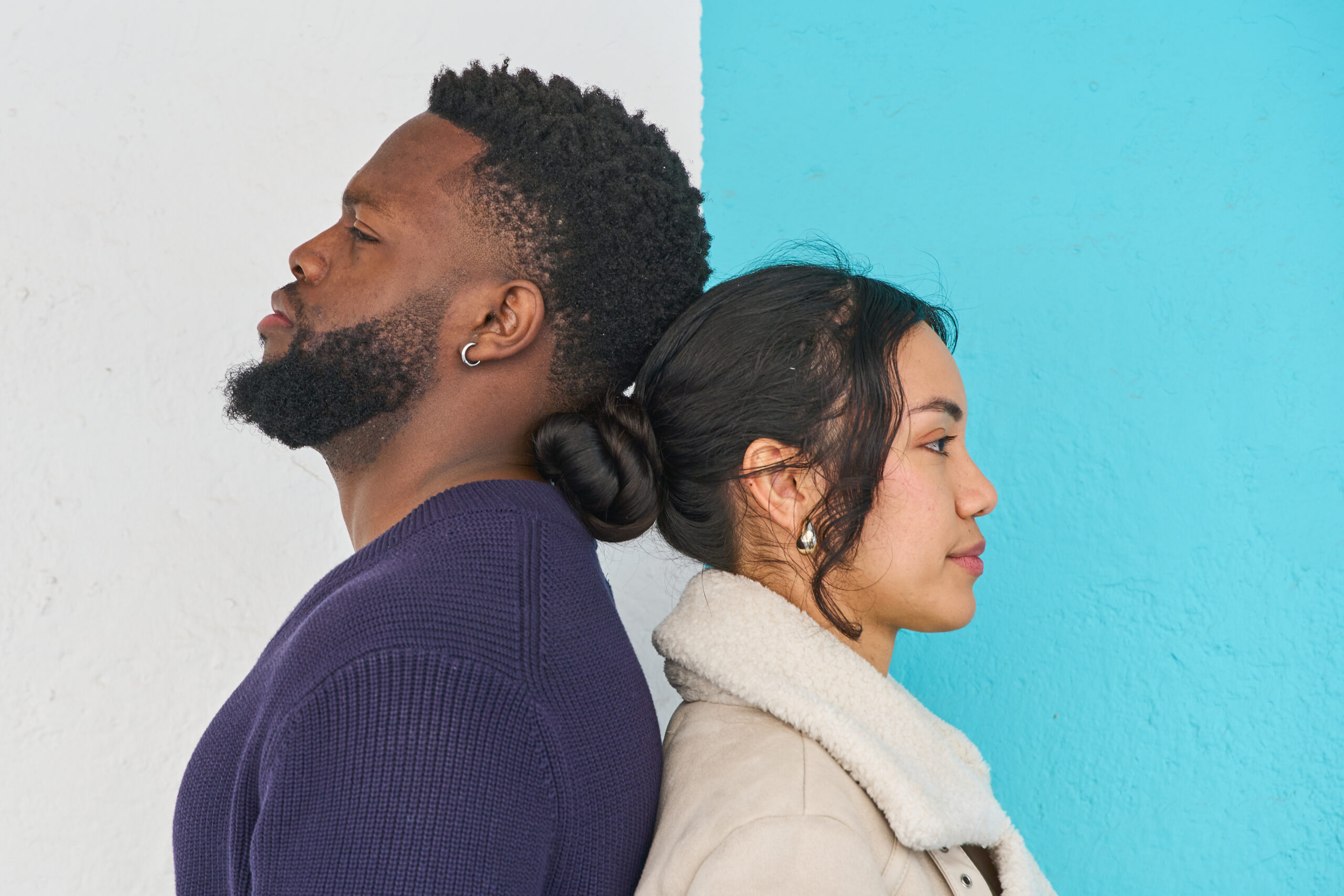 Man and woman with their backs together representing relationship problems, conflict, separation, and lack of communication